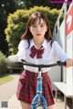 A young woman in a school uniform riding a bike.