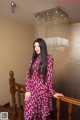 A woman in a red and blue dress standing on a staircase.