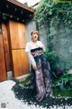 A woman standing in front of a wooden door.