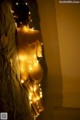 A naked woman with a string of lights around her body.